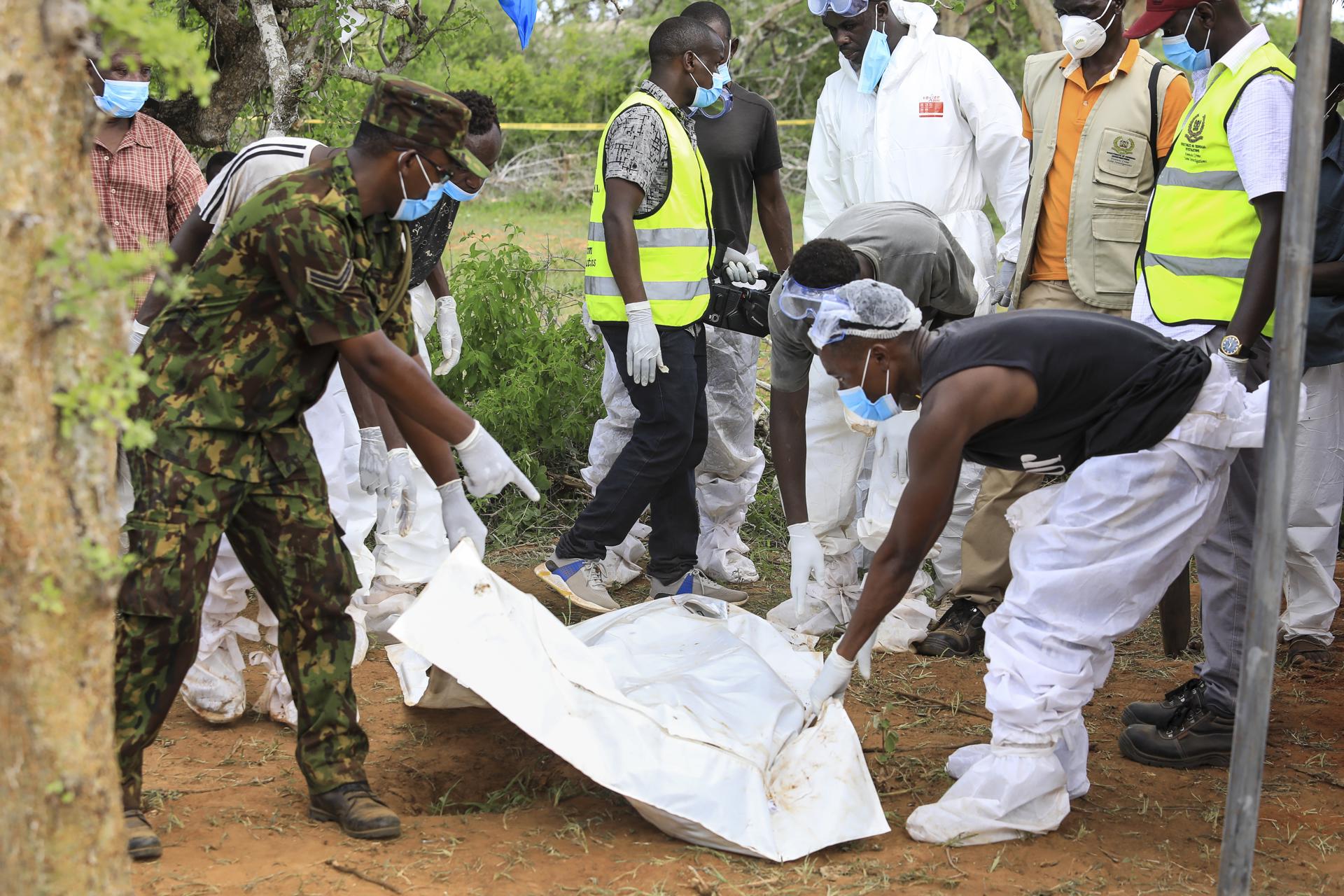 Kenyan homicide detectives and forensic experts from the Directorate of Criminal Investigations (DCI), examine exhumed bodies from several shallow mass graves of suspected members of a Christian cult after starving themselves to death, after allegedly being told by their controversial preacher Paul Mackenzie that they would go to heaven if they starved themselves to death, in the coastal Shakahola forest, in Kilifi, Kenya, 23 April 2023. EFE/EPA/STR
