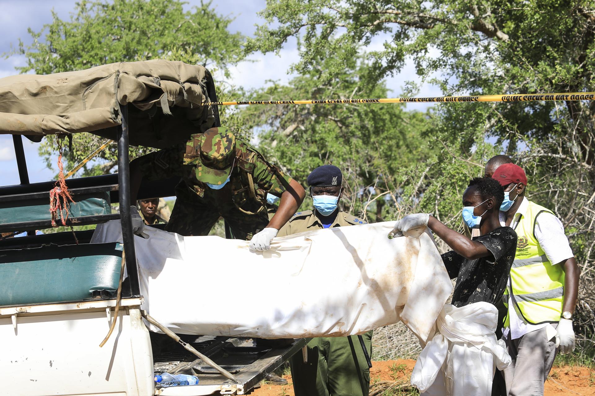 Kenyan homicide detectives and forensic experts from the Directorate of Criminal Investigations (DCI), examine exhumed bodies from several shallow mass graves of suspected members of a Christian cult after starving themselves to death, after allegedly being told by their controversial preacher Paul Mackenzie that they would go to heaven if they starved themselves to death, in the coastal Shakahola forest, in Kilifi, Kenya, 23 April 2023. EFE/EPA/STR