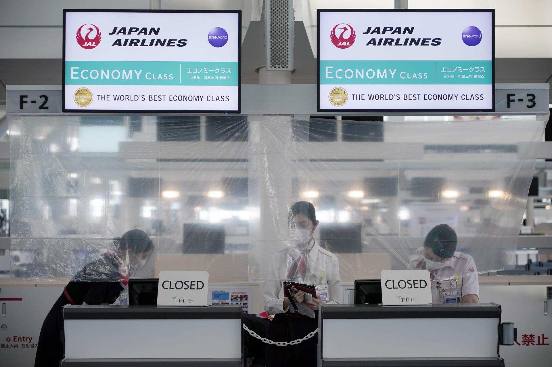 Japan Airlines (JAL) ground staff members stand behind a plastic sheet for protection against COVID-19 disease infection at a closed check in counter at Haneda Airport in Tokyo, Japan, 30 April 2020. EFE-EPA FILE/FRANCK ROBICHON
