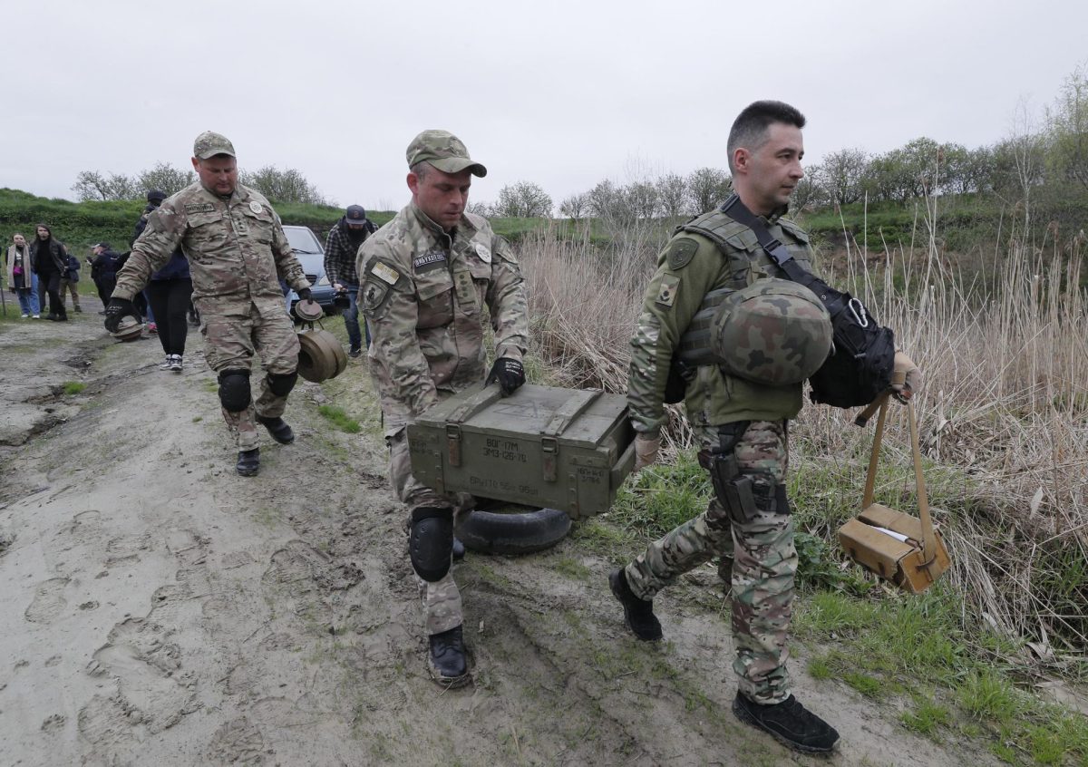 Zapadores ucranianos transportan cajas antes de la destrucción de minas antitanque y otros materiales explosivos encontrados cerca de la ciudad de Bucha, en Kiev, Ucrania.