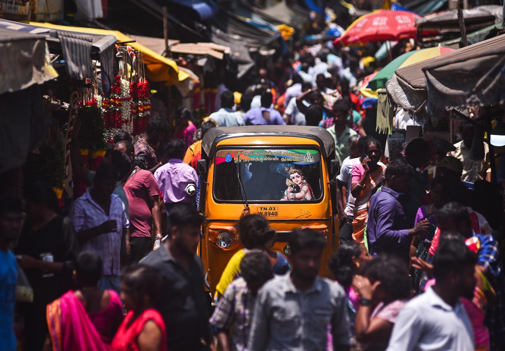 An auto-rickshaw driver passes through a crowded street, at a wholesale market, in Chennai, India, 14 April 2023. EFE/EPA/IDREES MOHAMMED