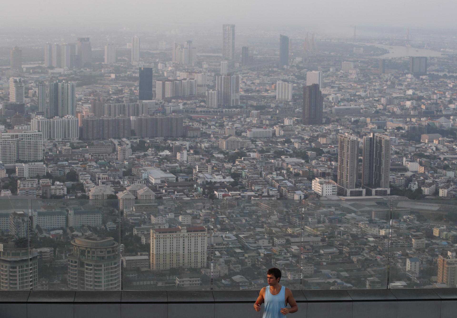 (FILE) A person warms up to perform yoga exercises as high-rise buildings are shrouded in smog and haze from heavy concentrations of fine particulate matter, in Bangkok, Thailand, 08 April 2023. EFE/EPA/RUNGROJ YONGRIT