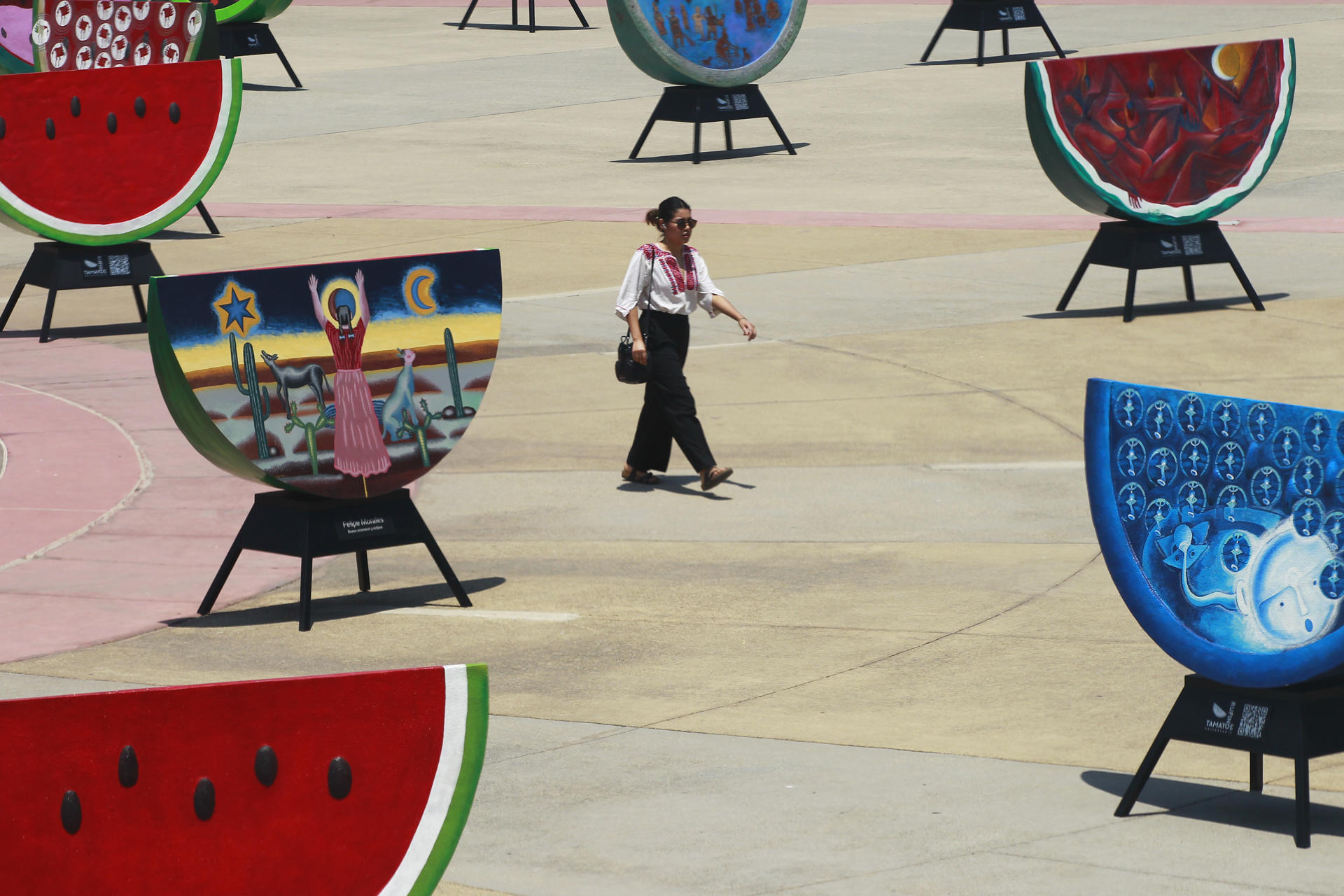 Visitors observe pieces of the exhibition "Watermelons and color: the legacy of Rufino Tamayo", on the esplanade of the Santander Performing Arts Complex in Guadalajara, Jalisco, Mexico, 17 April 2023 (issued 18 April 2023). EFE-EPA/Francisco Guasco
