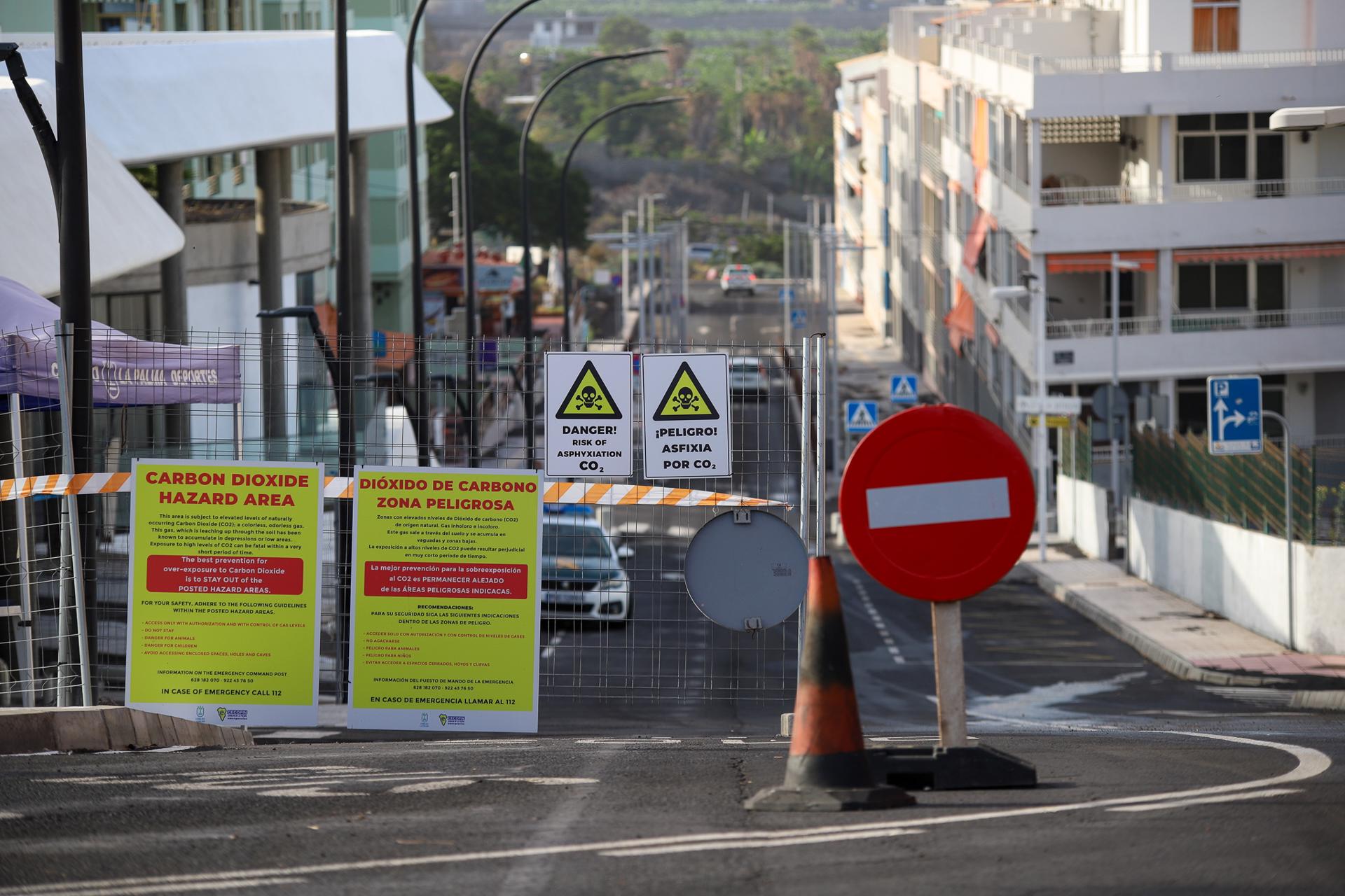Foto de archivo del núcleo turístico de Puerto Naos, de La Palma, con carteles que advierten del peligro que representa la concentración de dióxido de carbono. EFE/Luis G. Morera