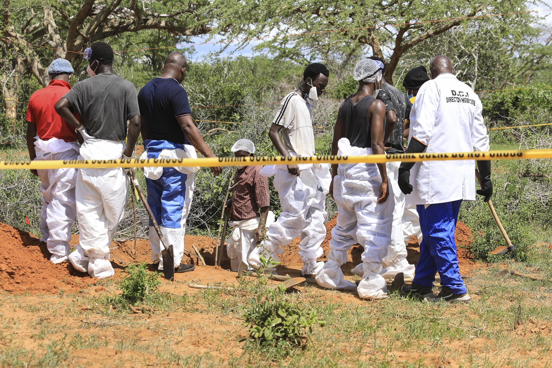 Kenyan homicide detectives and forensic experts from the Directorate of Criminal Investigations (DCI), examine exhumed bodies from several shallow mass graves of suspected members of a Christian cult after starving themselves to death, after allegedly being told by their controversial preacher Paul Mackenzie that they would go to heaven if they starved themselves to death, in the coastal Shakahola forest, in Kilifi, Kenya, 23 April 2023.  EFE/EPA/STR
