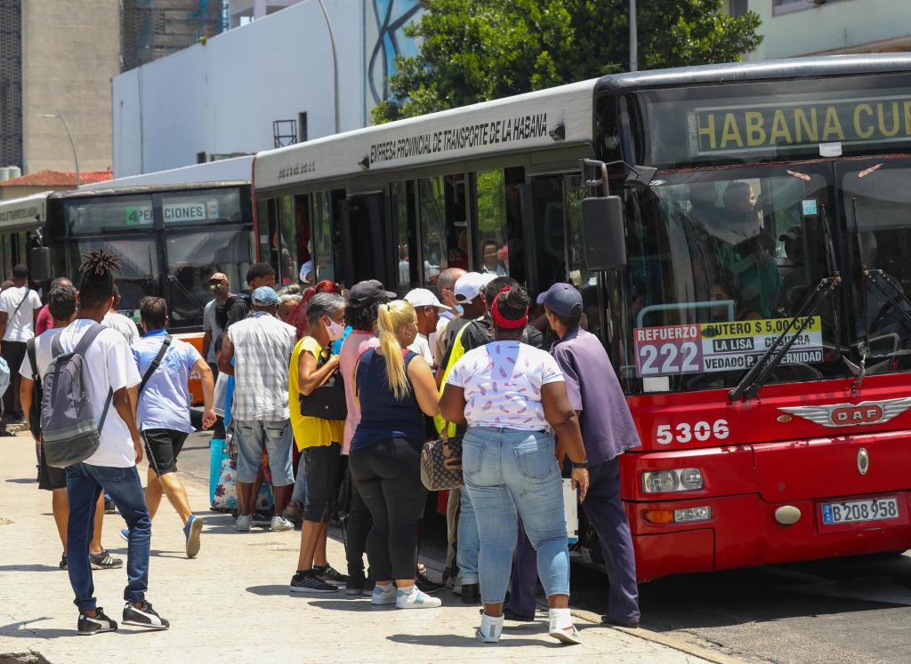 Varias personas intentan subir a un ómnibus, hoy en La Habana (Cuba). EFE/Yander Zamora
