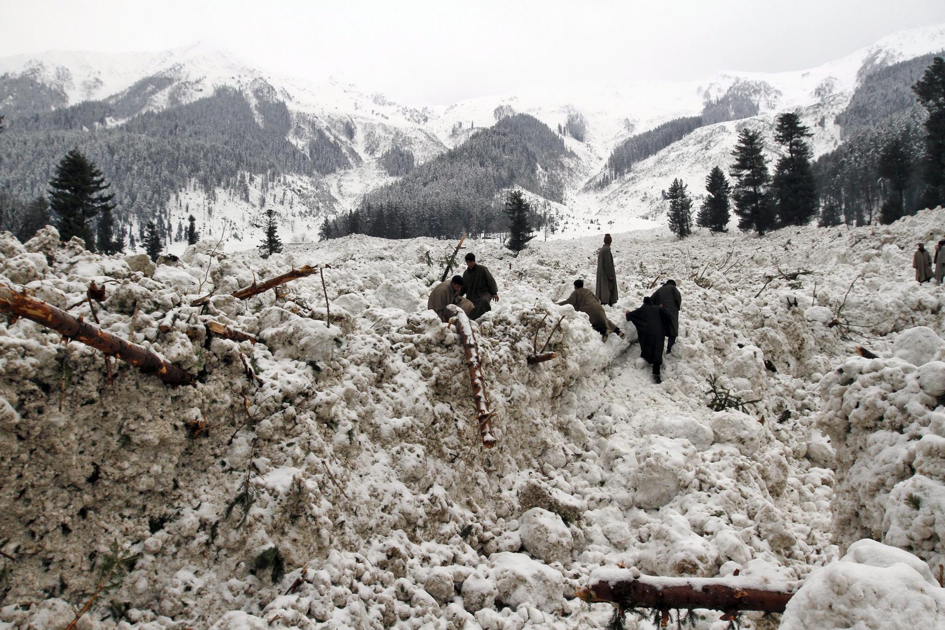 Villagers search for their belongings after their huts were buried under snow due to avalanche in Ramwari, 70 km from Srinagar, the summer capiat of Indian Kashmir, 23 February 2012. EPA/FILE/FAROOQ KHAN
