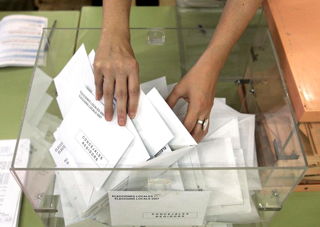 Las manos de la presidenta de una mesa electoral de València, extrae las papeletas para comenzar el recuento de los votos emitidos en unas elecciones anteriores. EFE/Juan Carlos Cárdenas
