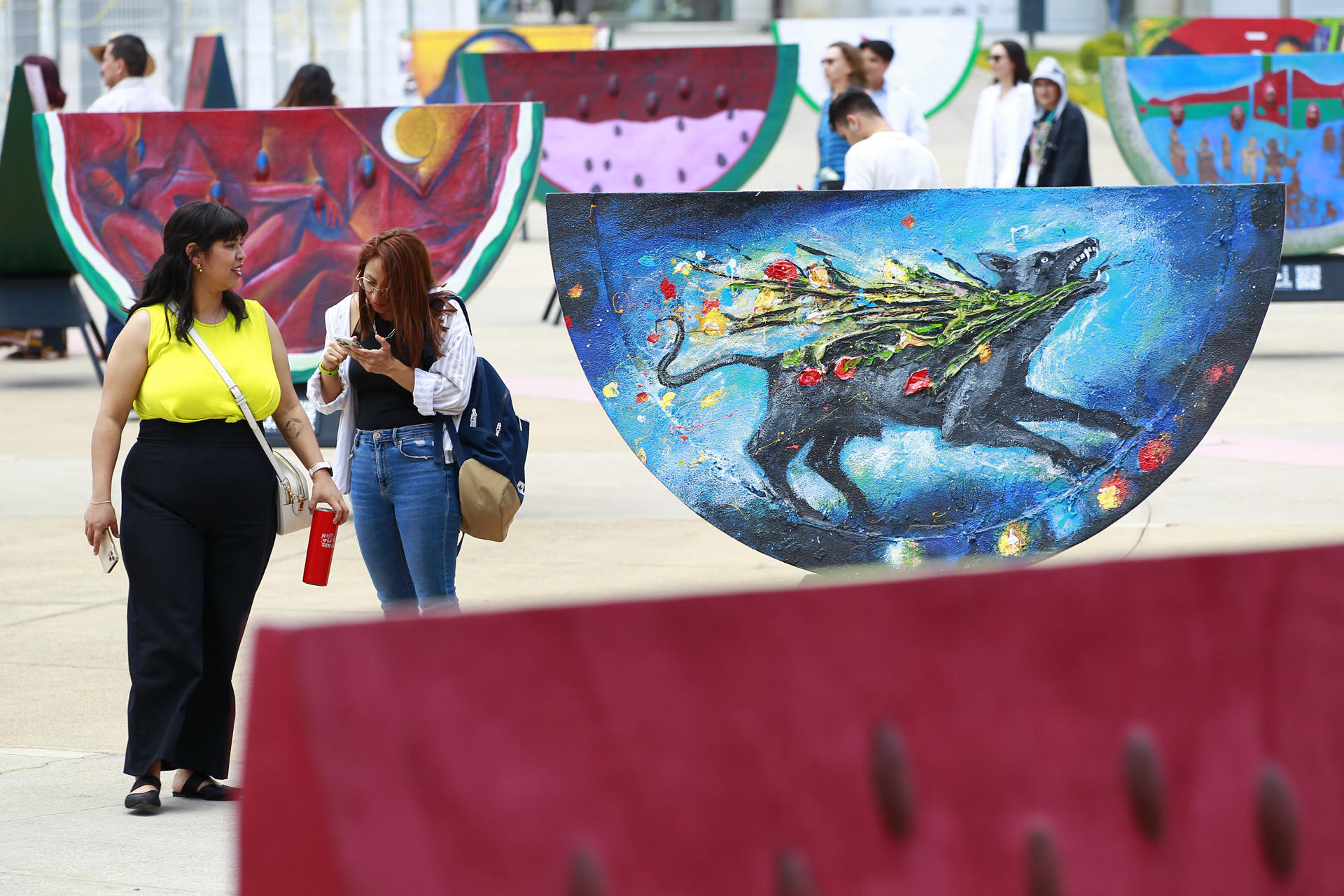Visitors observe pieces of the exhibition "Watermelons and color: the legacy of Rufino Tamayo", on the esplanade of the Santander Performing Arts Complex in Guadalajara, Jalisco, Mexico, 17 April 2023 (issued 18 April 2023). EFE-EPA/Francisco Guasco