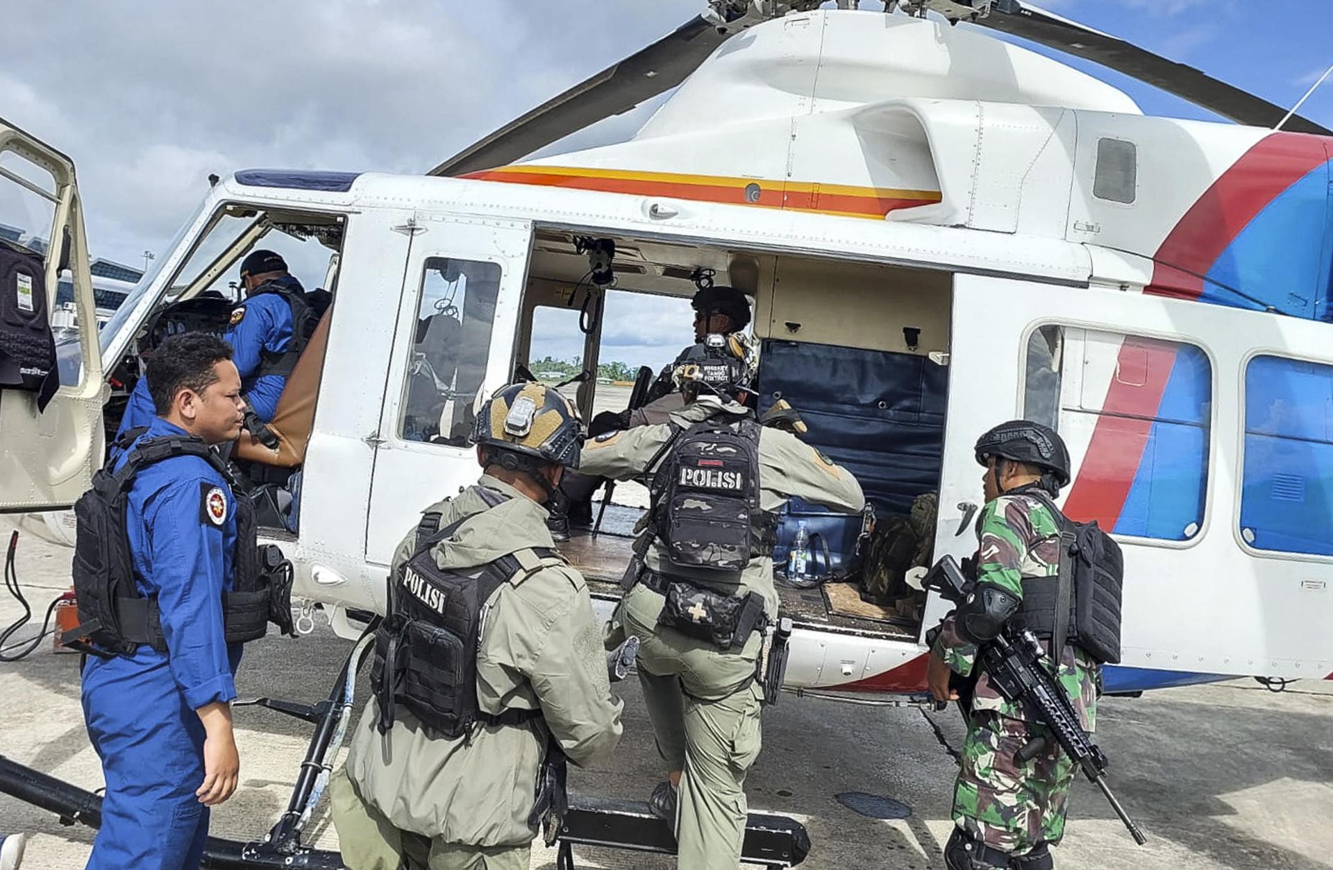 A handout photo made available by Papua Police Headquarters shows Indonesian police and military personnel boarding an helicopter during a search and rescue operation for Susi Air pilot and passengers at an airport in Timika, Papua, Indonesia 08 February 2023. EFE/EPA/FILE/PAPUA POLICE HEADQUARTERS / HANDOUT HANDOUT HANDOUT EDITORIAL USE ONLY/NO SALES
