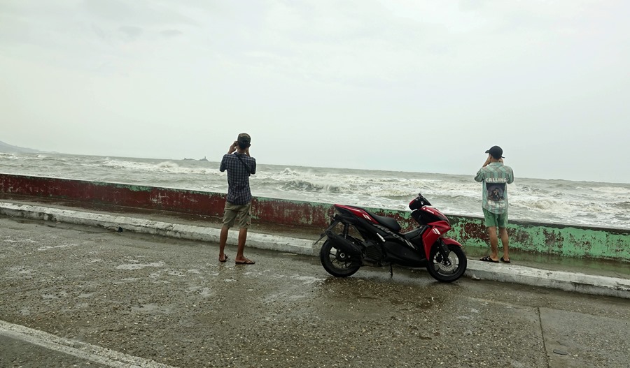 Varias personas hacen fotos antes de la llegada del ciclón Mocha a Birmania.