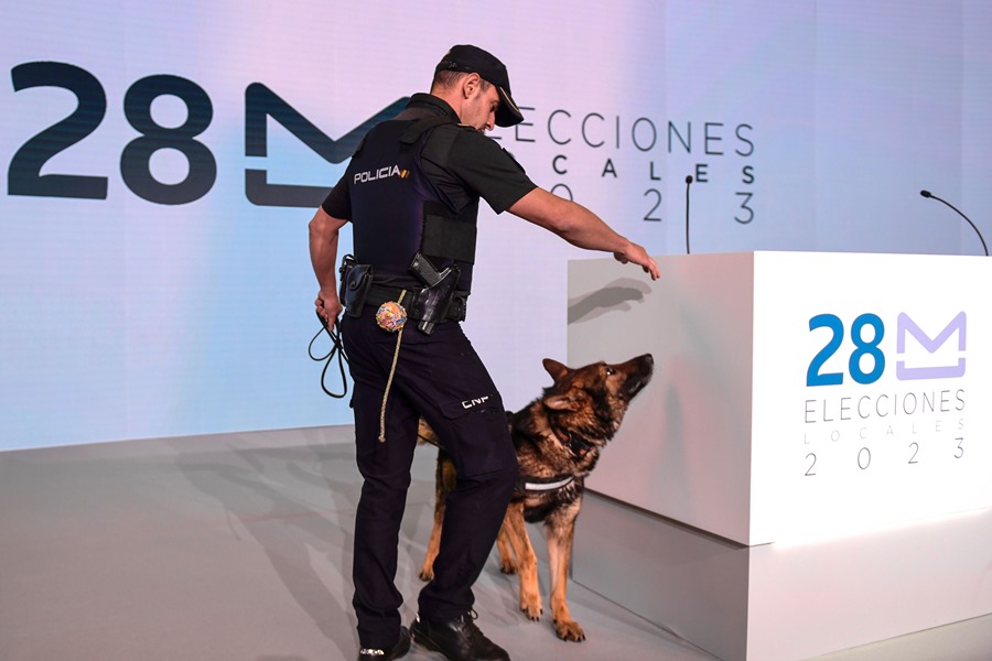 Un policía junto a su perro revisan las instalaciones del Centro Nacional de Difusión de Datos Electorales del 28-M en el recinto ferial IFEMA de Madrid.