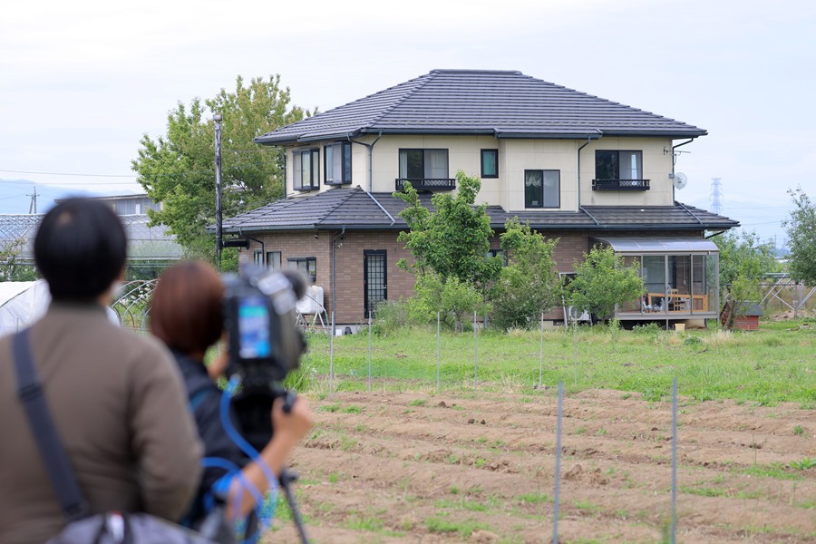 A television crew films the house where a gunman barricaded himself, in Nakano, central Japan, on May 26.