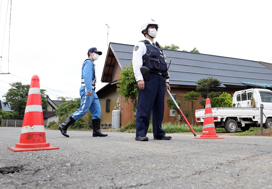 Police officers control the access road to the house where an armed man entrenched himself in Nakano, in central Japan, on May 26.