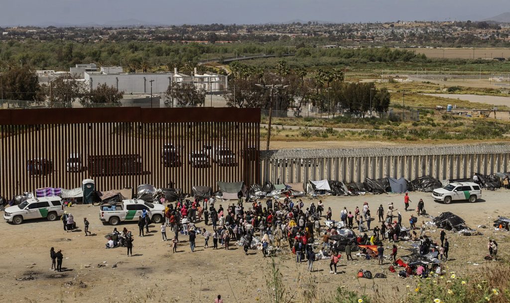 Migrantes permanecen en un campamento junto al muro fronterizo con EEUU, en Tijuana, Baja California (México)