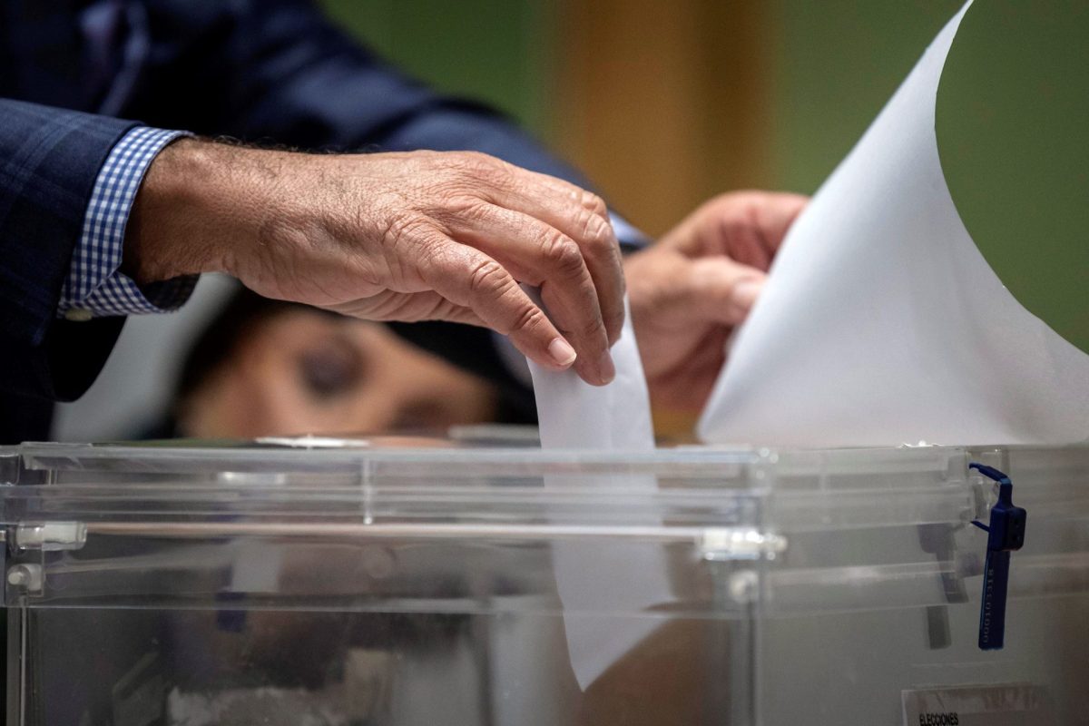 Una persona deposita su voto en una urna electoral