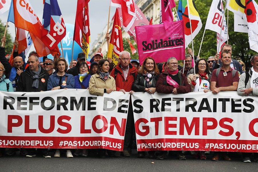 Principales líderes sindicales franceses portan una pancarta que dice "Reforma de pensiones, trabajar más tiempo no" durante la marcha anual del Primero de Mayo en París, Francia.