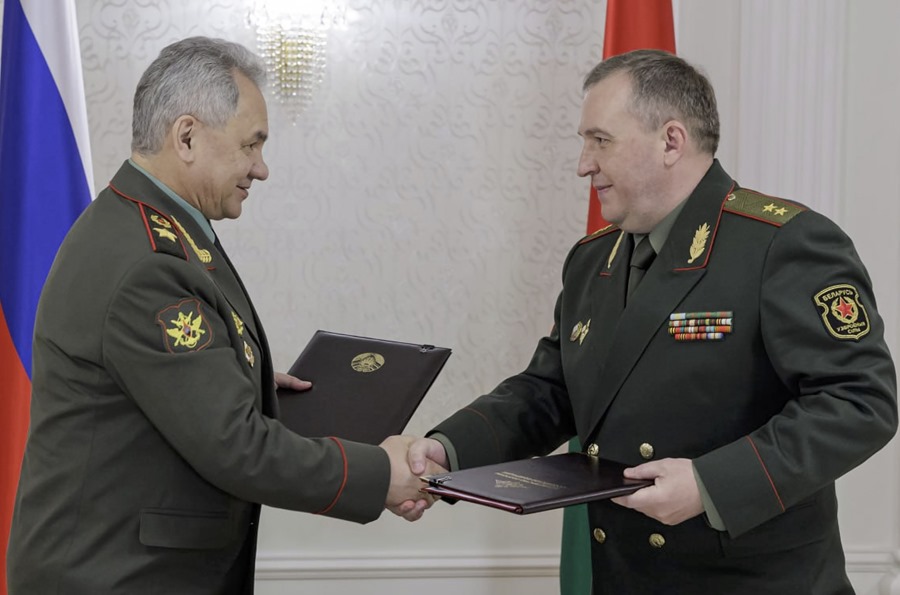 This image provided by the Russian Defense Ministry shows Defense Minister Sergei Shoigu (L) and Belarusian Defense Minister Viktor Khrenin exchanging signed documents to keep Russian non-strategic nuclear weapons on Belarusian territory.