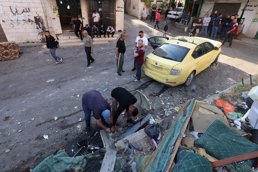 Palestinos inspeccionan un vehículo dañado tras una operación de las fuerzas israelíes en el campo de refugiados de Nur Shams, cerca de la ciudad cisjordana de Tulkarem, este 11 de mayo