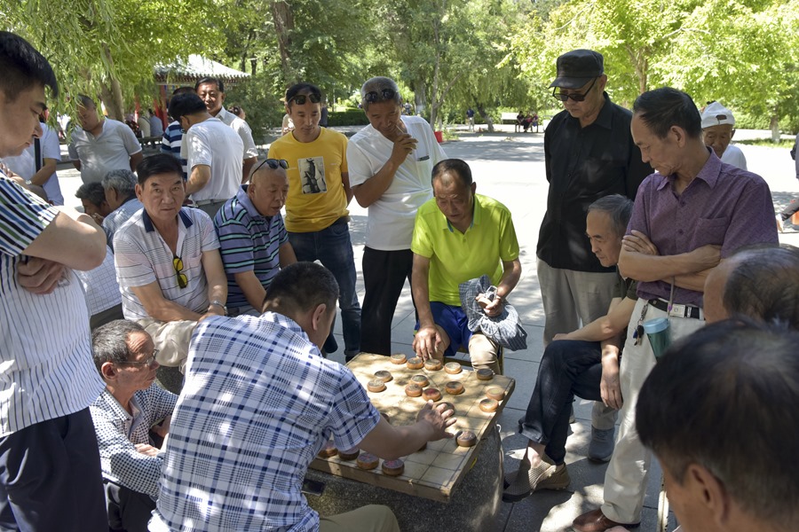 Un grupo de hombres juega al ajedrez en un parque en Pekín, China.
