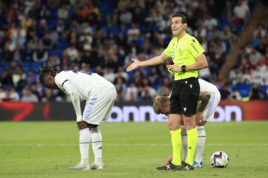 El centrocampista francés del Real Madrid, Eduardo Camavinga (i) se duele delante del colegiado Martínez Munuera, durante el partido de ayer. Confirmado esguince