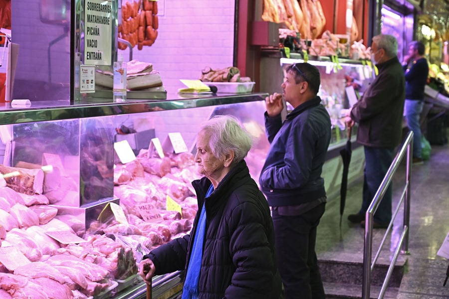 Customers in a market in Madrid.  Economists forecast growth