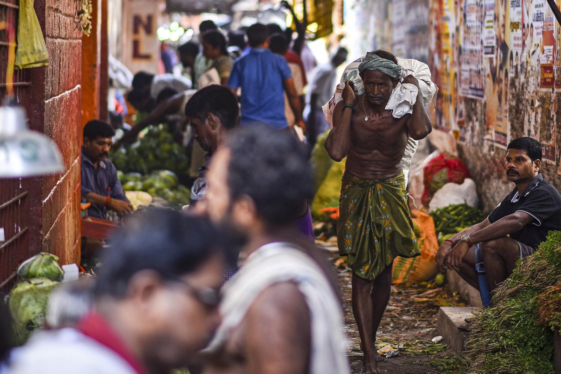 An Indian laborer carries a sack of vegetables at a market, in Chennai, India, 31 May 2023. EFE-EPA/IDREES MOHAMMED
