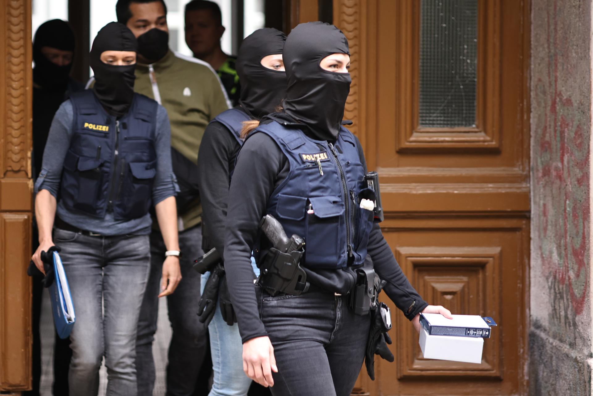 Police officers with face masks leave a residential building during a raid in Berlin, Germany, 24 May 2023. EFE/EPA/CLEMENS BILAN