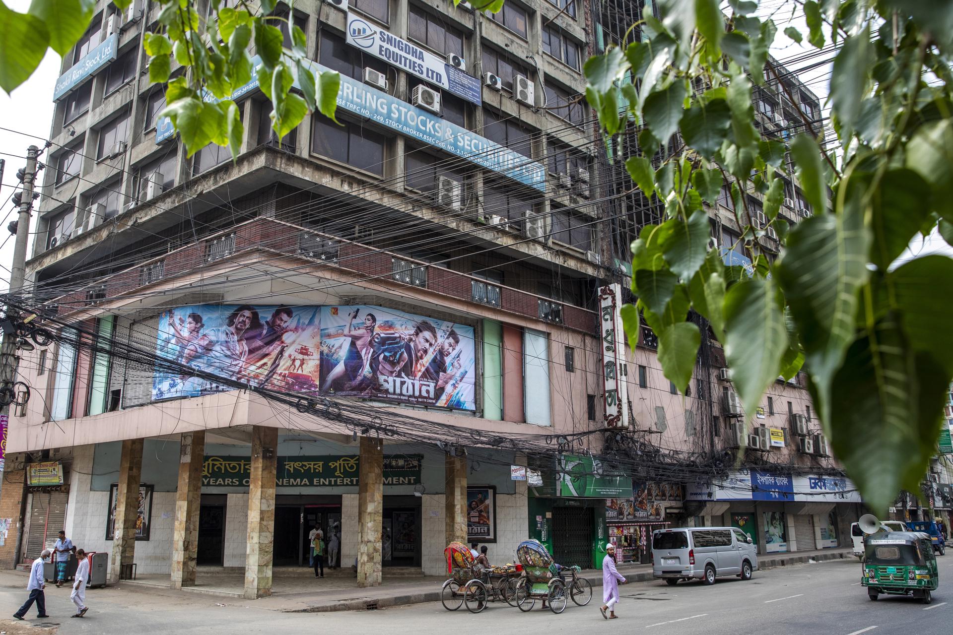 People walk past a banner depicting the Indian Hindi-language movie 'Pathaan' displayed outside the Modhumita Cinema Hall in Dhaka, Bangladesh, 12 May 2023. EFE-EPA/MONIRUL ALAM
