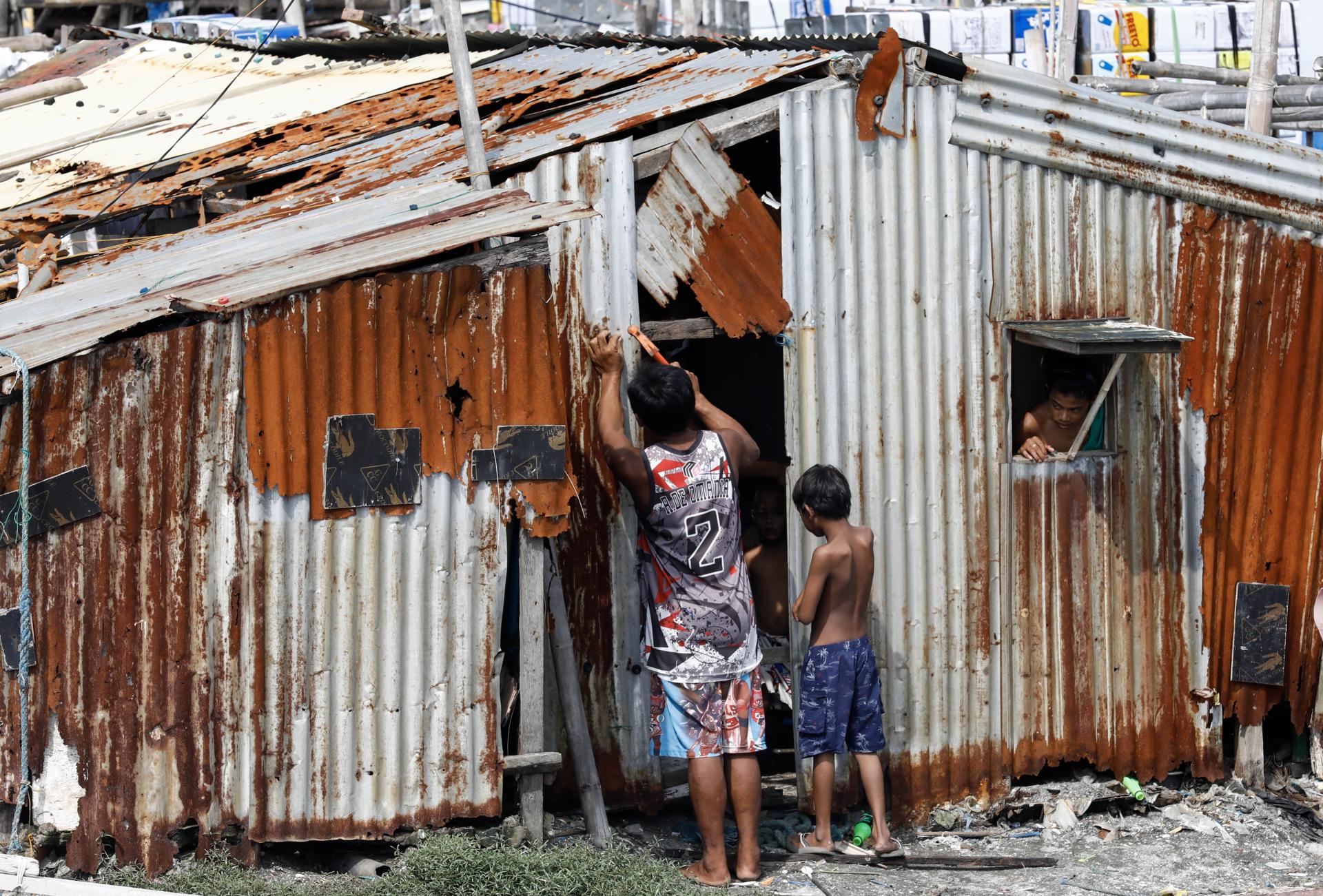 A resident fixes damages on a community shed at a coastal village in Navotas City, Metro Manila, Philippines, 26 May 2023. EFE-EPA/ROLEX DELA PENA