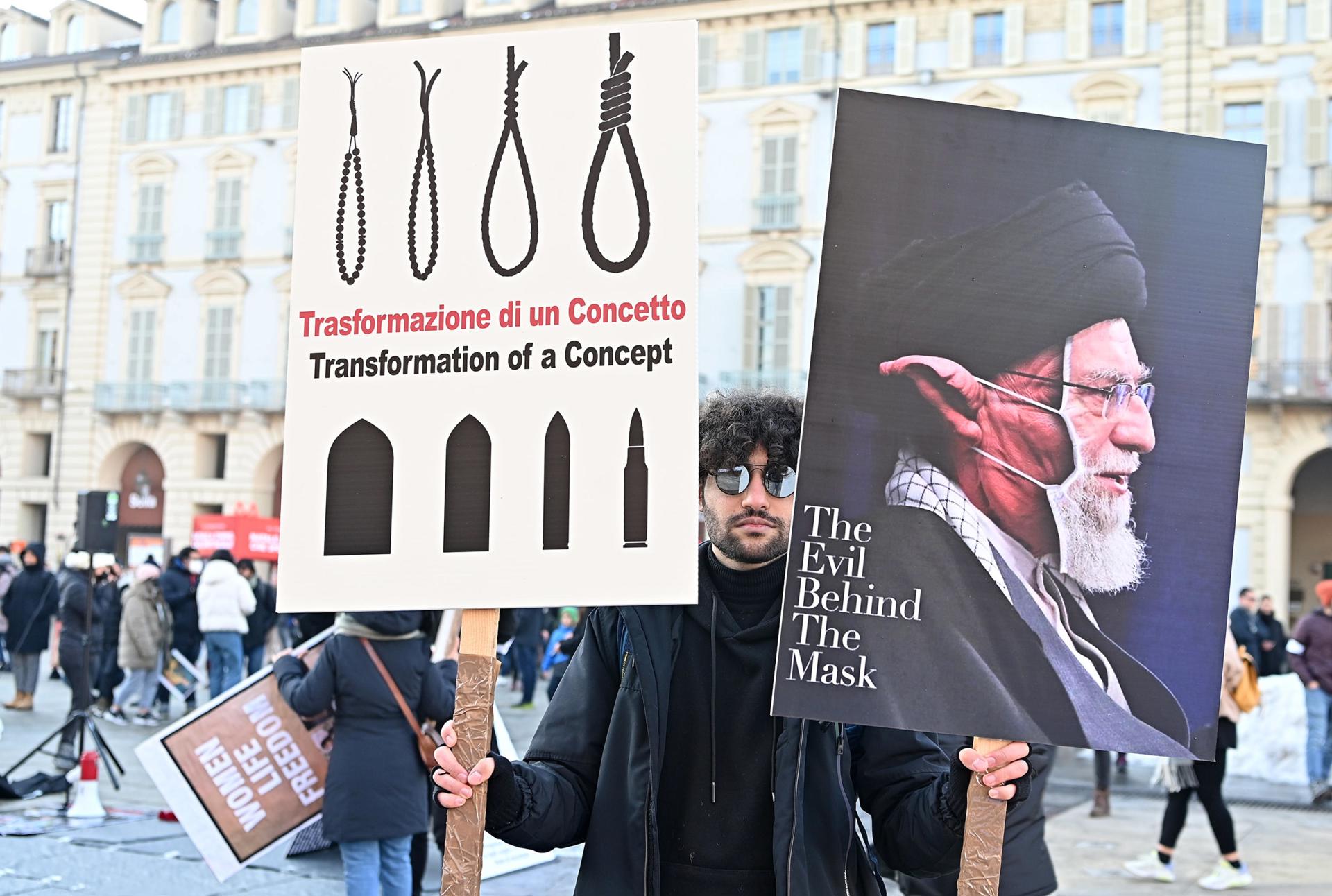 A protester holds placards during a demonstration against Iran's regime staged by the Iranian community, in Turin, Italy, 17 December 2022, following Iran's sentencing to death and public execution of two young demonstrators, Mohsen Shekari and Majidreza Rahnavard, for participating in demonstrations against the regime. EFE-EPA FILE/ALESSANDRO DI MARCO
