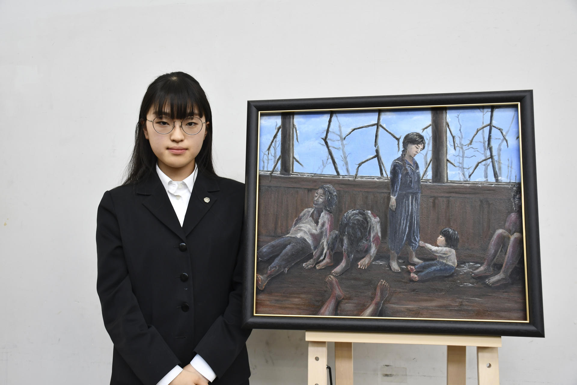 A student from Motomachi High School poses next to a painting while she takes part in a program to capture the memories of the survivors of the atomic bomb in Hiroshima, Japan, 17 May 2023. EFE/ Edurne Morillo