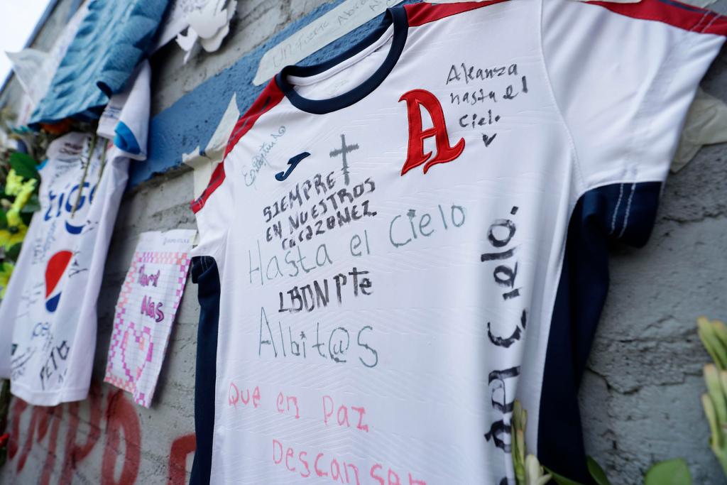 Fotografía de camisetas y flores hoy en un homenaje a los aficionados fallecidos tras una estampida humana durante un partido entre Alianza y el Futbolistas Asociados Santanecos el pasado sábado, en las afueras del Estadio Cuscatlán, en San Salvador (El Salvador). EFE/Rodrigo Sura
