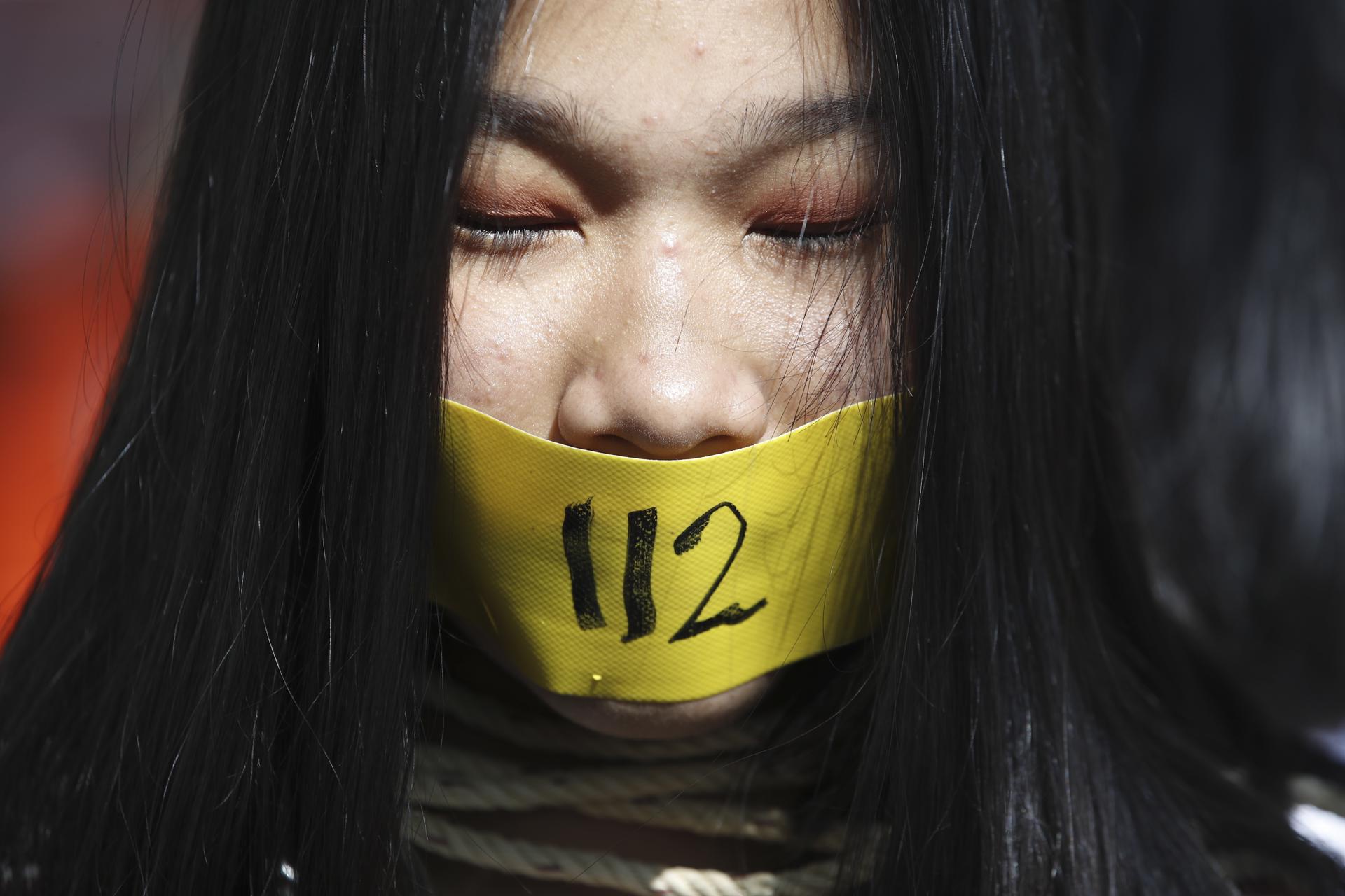 An protester covers her mouth during a rally calling to lift the section 112 of the Thai Criminal Code that criminalises lese majeste, in front of the United Nations building in Bangkok, Thailand, 10 December 2020. EFE-EPA FILE/DIEGO AZUBEL