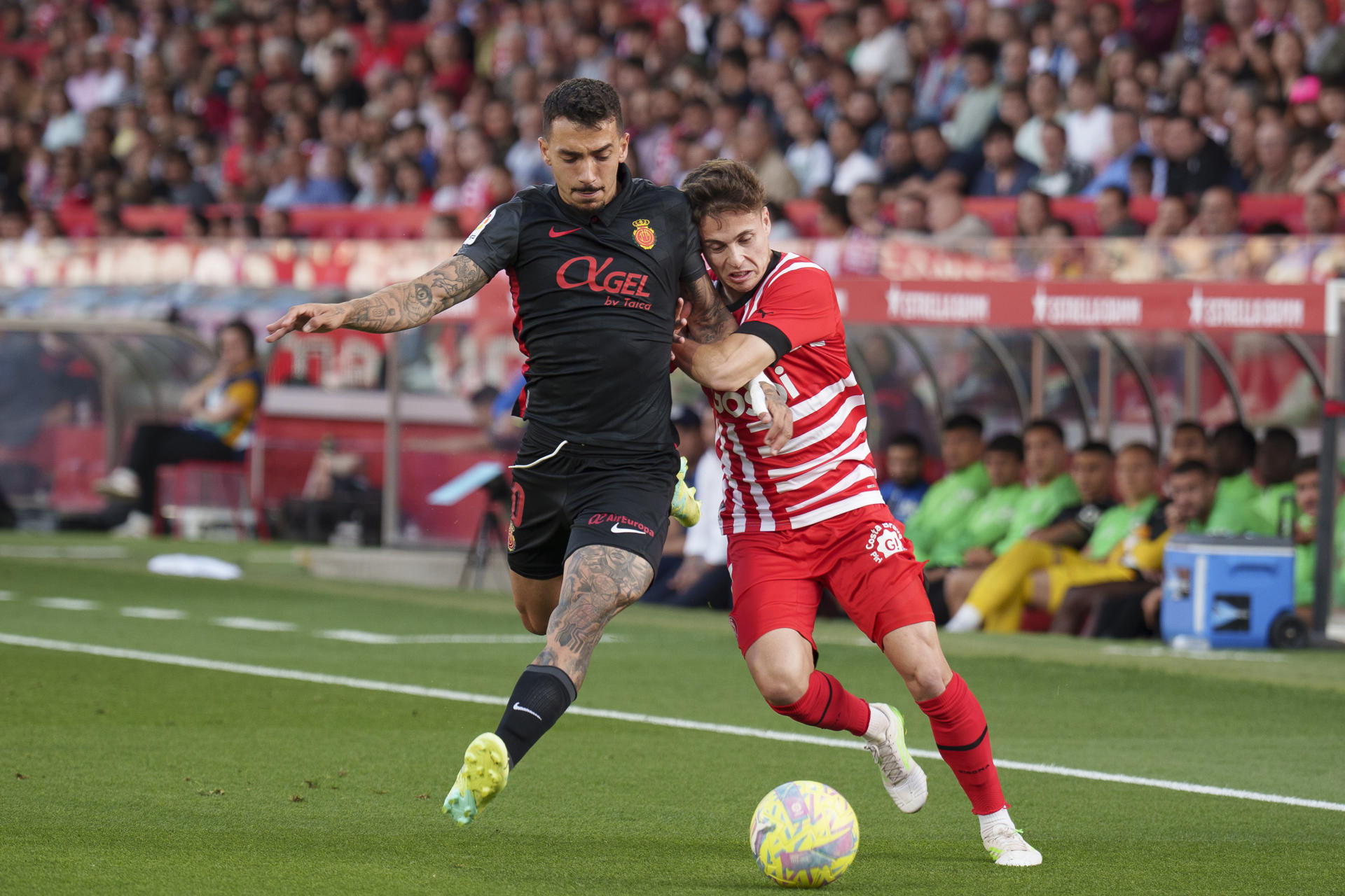 Rodrigo Riquelme (d) del Girona FC disputa un balón ante Antonio Sánchez del Mallorca este jueves, durante un partido de LaLiga entre el Girona FC y el R.C.D Mallorca, en el estadio municipal de Montilivi, en Girona (España). EFE/ David Borrat
