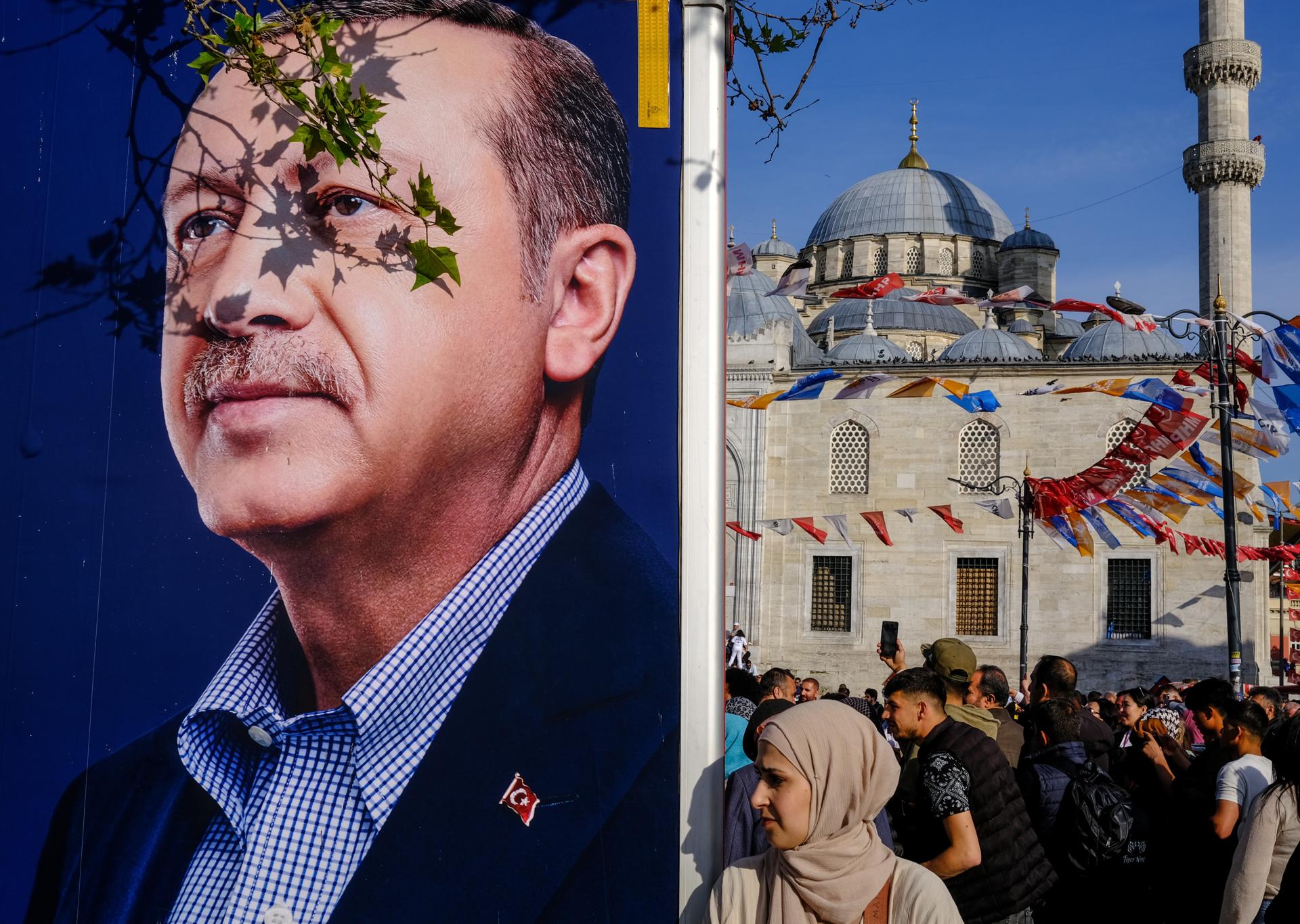 A woman walks past a campaign van showing the picture of Turkish President Recep Tayyip Erdogan in Istanbul, Turkey, 08 May 2023. EFE/EPA/SEDAT SUNA