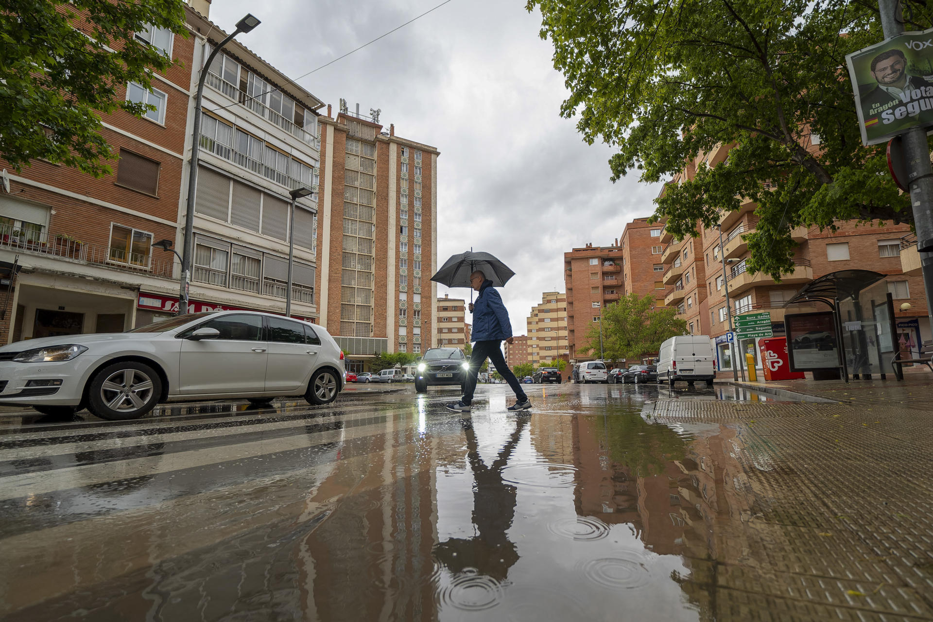 Un hombre se protege de la lluvia bajo un paraguas en Teruel. EFE/Antonio García