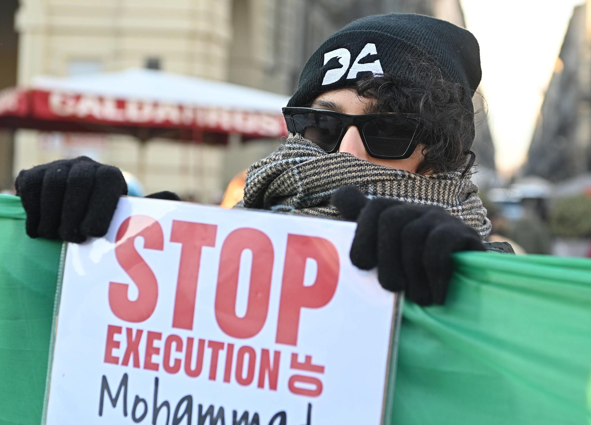 A protester holds a placard as people attend a demonstration against Iran's regime staged by the Iranian community, in Turin, Italy, 17 December 2022, following Iran's sentencing to death and public execution of two young demonstrators, Mohsen Shekari and Majidreza Rahnavard, for participating in demonstrations against the regime. EFE-EPA FILE/ALESSANDRO DI MARCO
