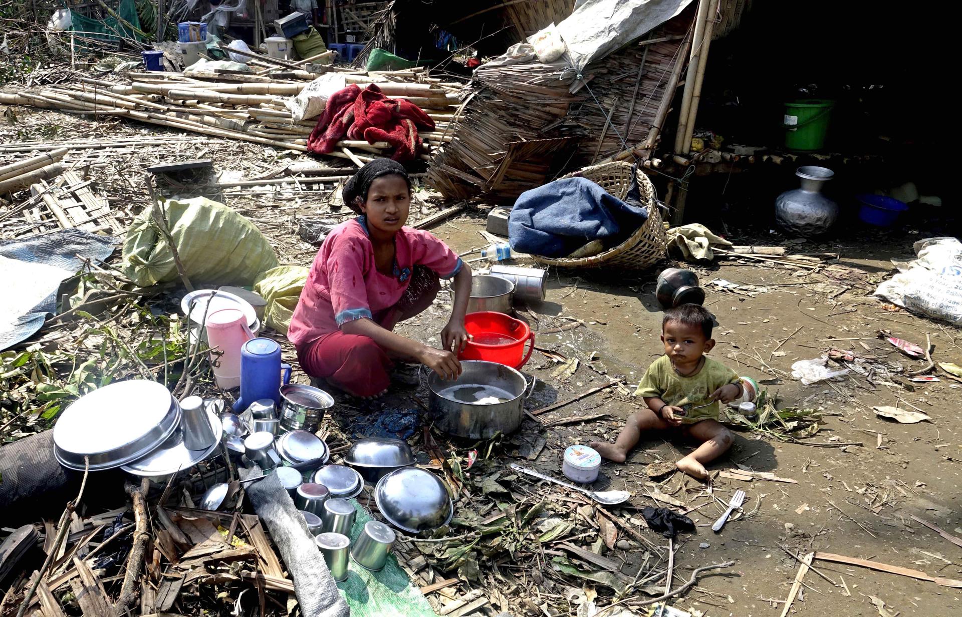A Rohingya woman and her child amid the destruction caused by Cyclone Mocha at a refugee camp. EFE/EPA/STRINGER