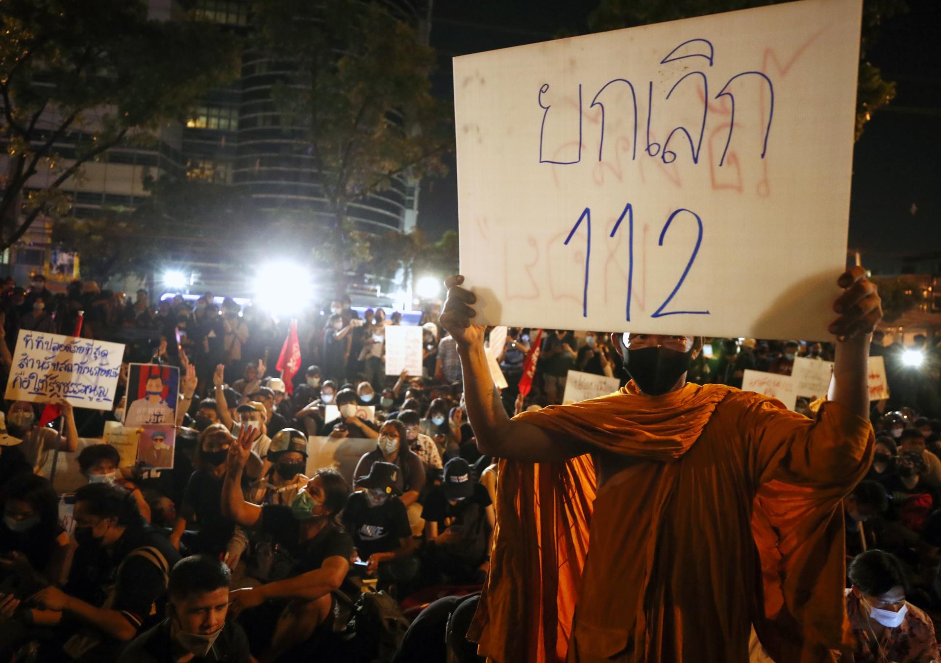 A Thai Buddhist monk holds a banner reading 'abolition the section 112 criminal code' during a rally calling to free their jailed leaders and revoke the lese majeste law outside the criminal court in Bangkok, Thailand, 06 March 2021. EFE-EPA FILE/DIEGO AZUBEL
