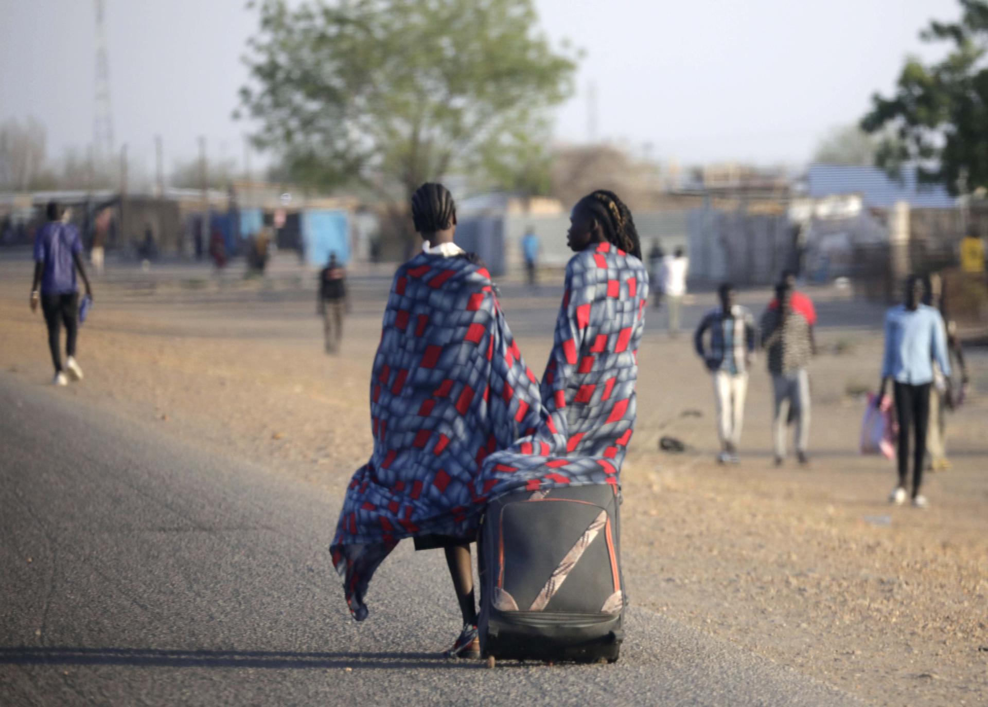 Civiles que han huido de los combates en Sudán caminan hacia el centro de tránsito de refugiados de la ciudad de Renk, en el estado del Alto Nilo, en Sudán del Sur,