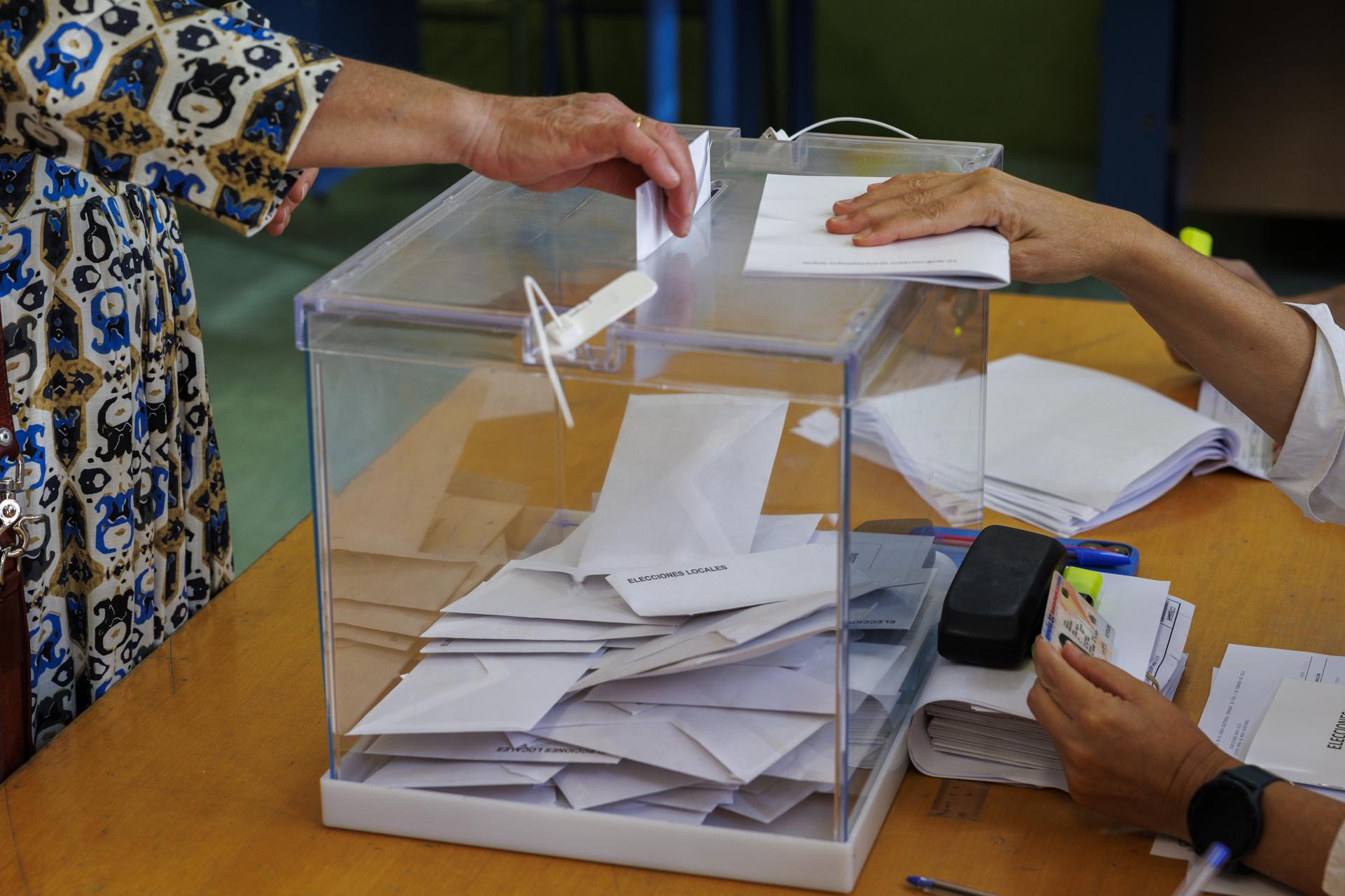 Una mujer introduce su voto en una urna en un colegio electoral. EFE/ Julio Muñoz.