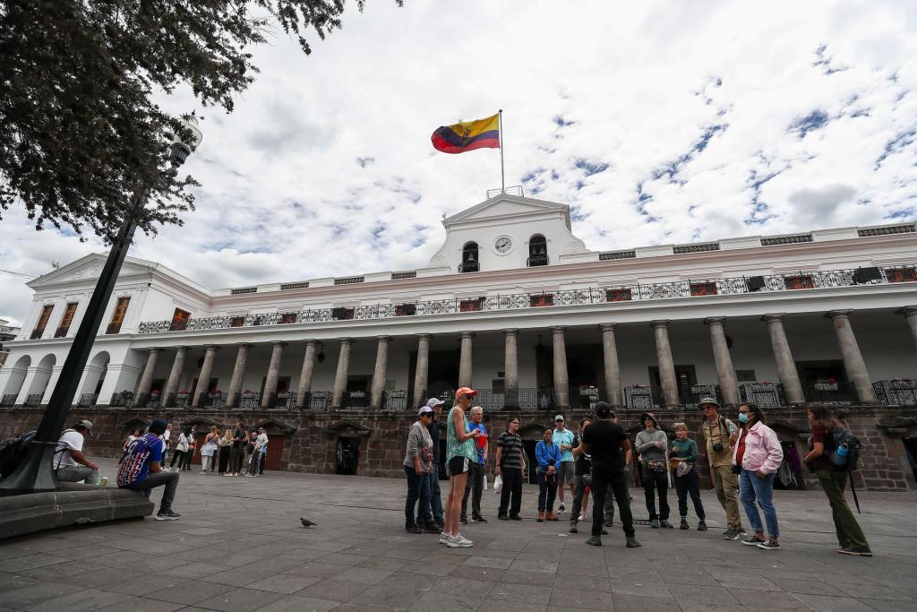 Ciudadanos ecuatorianos caminan a las afueras del Palacio de Gobierno hoy, en Quito (Ecuador). EFE/José Jácome
