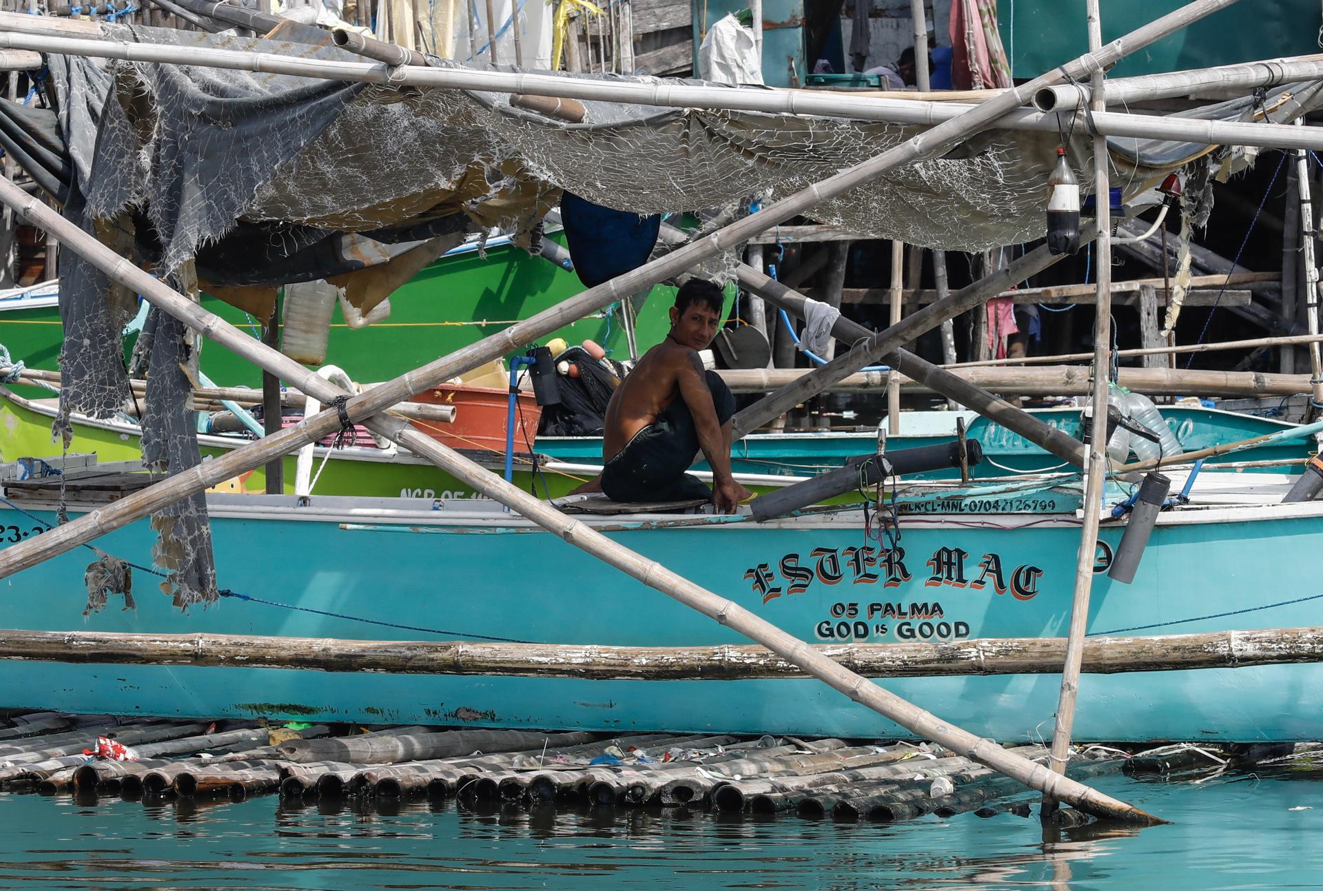 A fisherman sits in his boat docked at a coastal village in Navotas City, Metro Manila, Philippines, 26 May 2023. EFE-EPA/ROLEX DELA PENA
