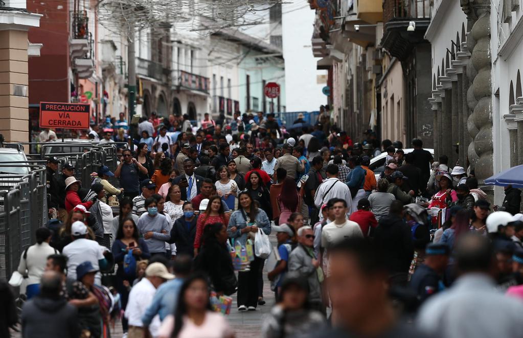 Personas caminan a las afueras del Palacio de Gobierno hoy, en Quito (Ecuador). EFE/José Jácome
