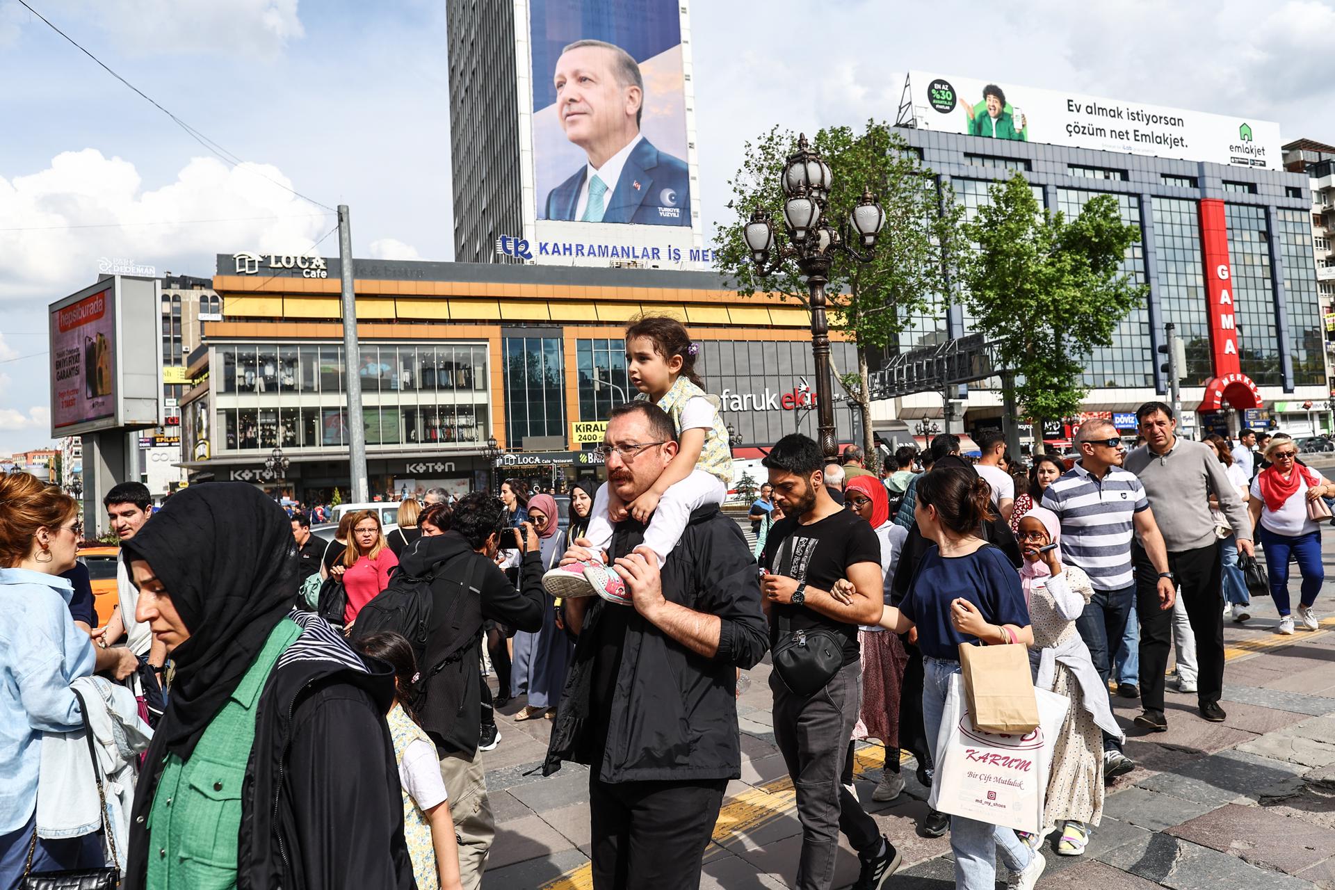 People walk in front of the poster of Turkish President Recep Tayyip Erdogan in Ankara, Turkey, 27 May 2023. EFE/EPA/SEDAT SUNA