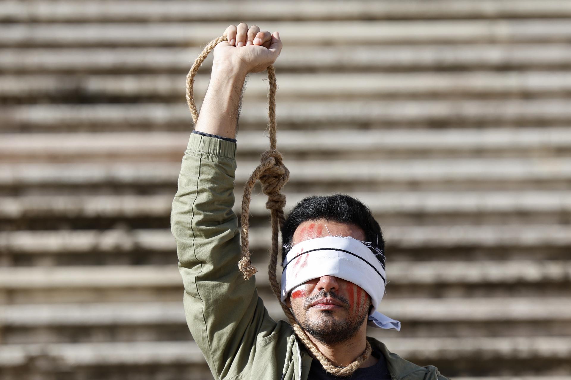 A demonstrator from the Iranian Portuguese community protests in front of the Parliament building following Iran's sentencing to death and public execution of two young demonstrators, Mohsen Shekari and Majidreza Rahnavard, for participating in demonstrations against the regime, in Lisbon, Portugal, 16 December 2022. EFE-EPA FILE/ANTONIO PEDRO SANTOS