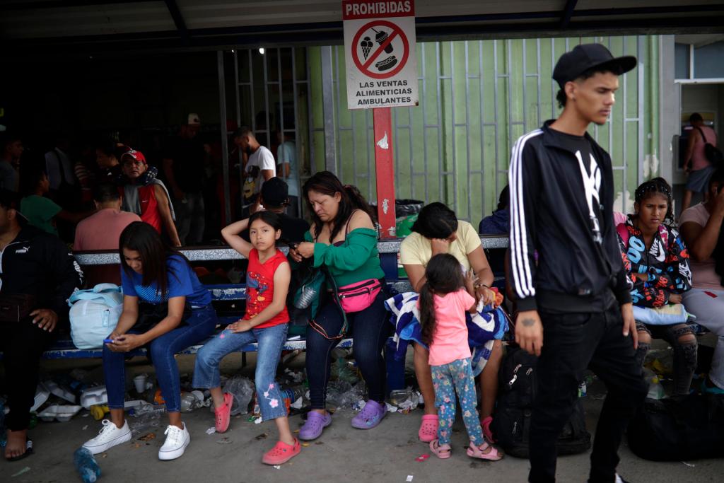 Migrantes venezolanos esperan su traslado en bus hacia Nicaragua hoy, en Paso Canoas, población fronteriza entre Panamá y Costa Rica. EFE/Bienvenido Velasco

