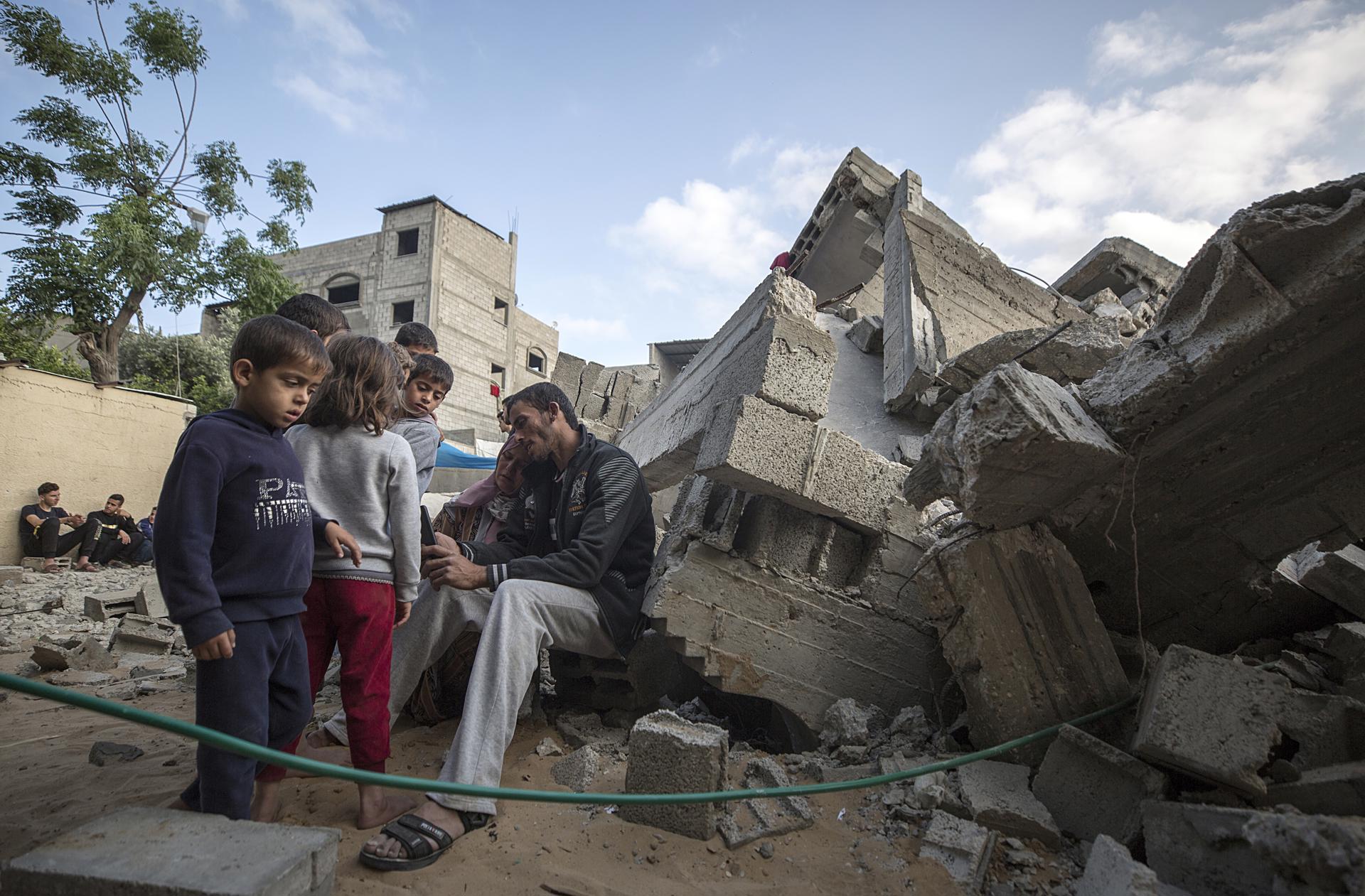 Members of the Nabhan family sit near the rubble of their house following an Israeli air strike in Beit Lahiya town in northern Gaza Strip, 13 May 2023. EFE-EPA/HAITHAM IMAD