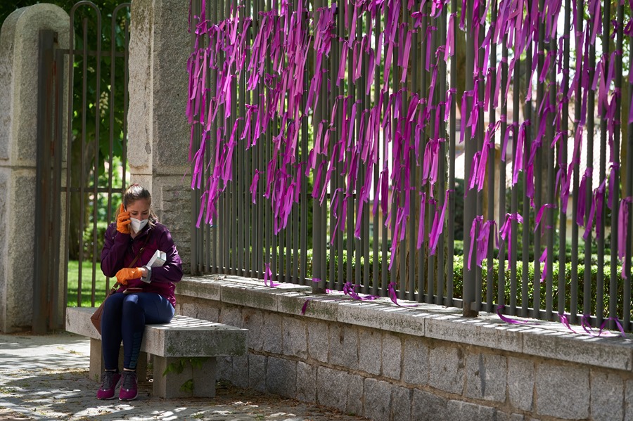 A woman next to a fence full of ties against gender violence